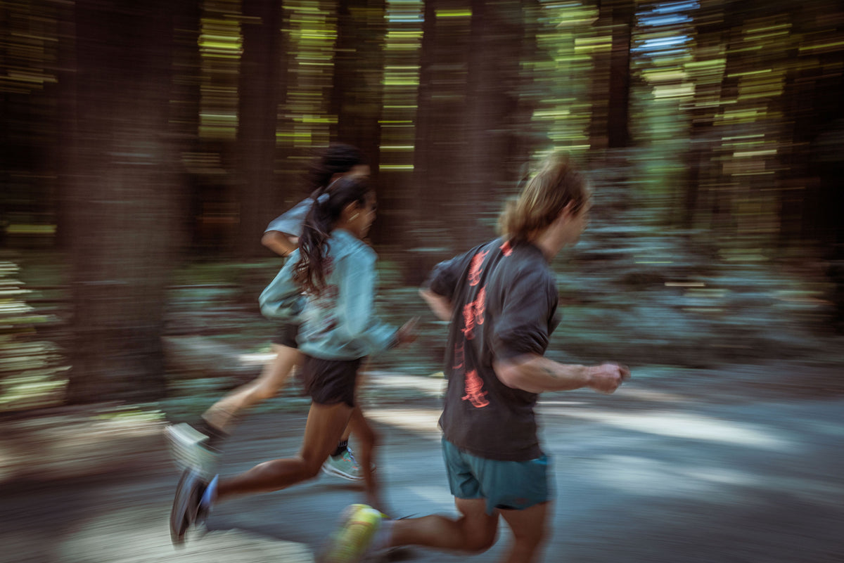 Runners in Run Local gear on a forest trail