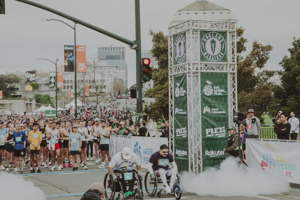 Wheelchair athletes start the Oakland Marathon as runners cheer at the start line